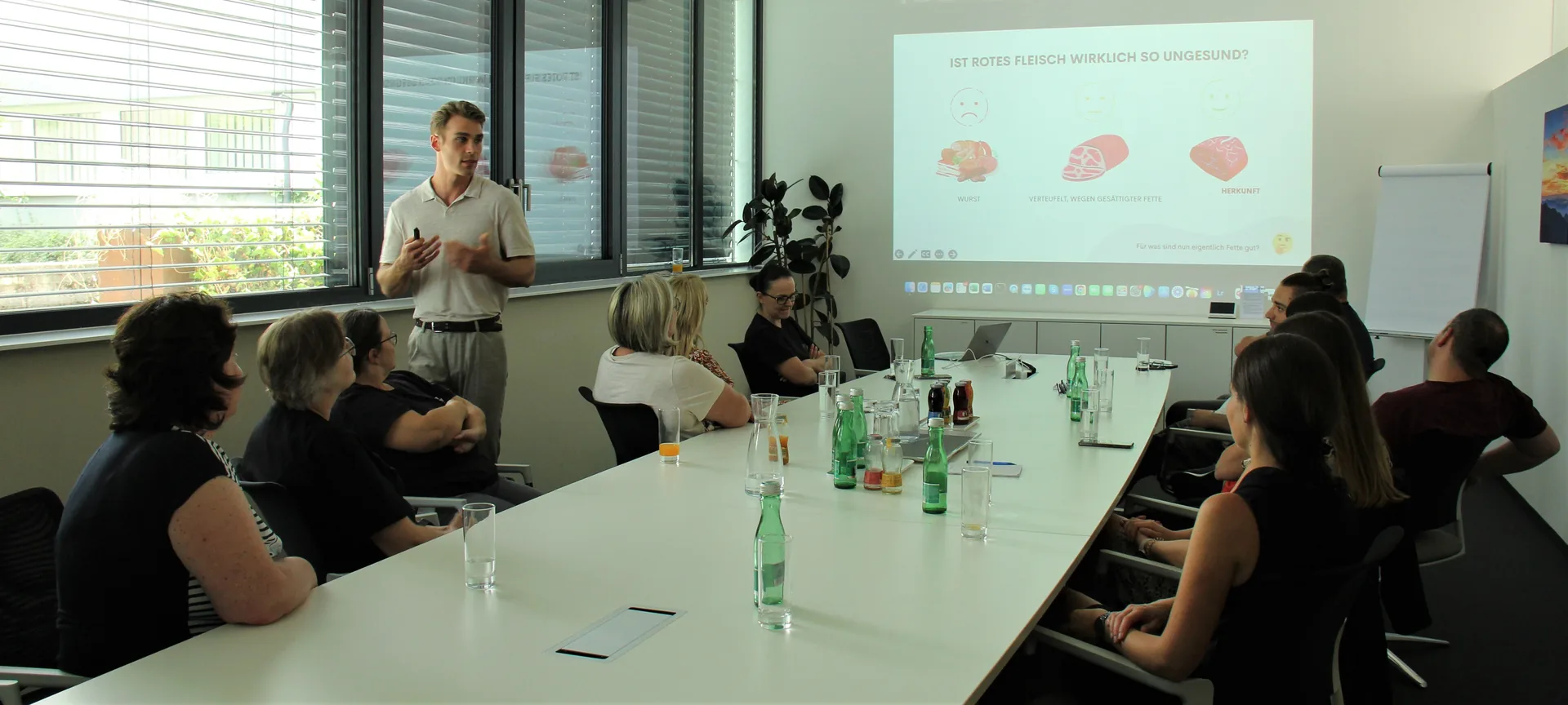 Markus Hoffelner hält einen Ernährungsvortrag vor einem Team im Besprechungsraum